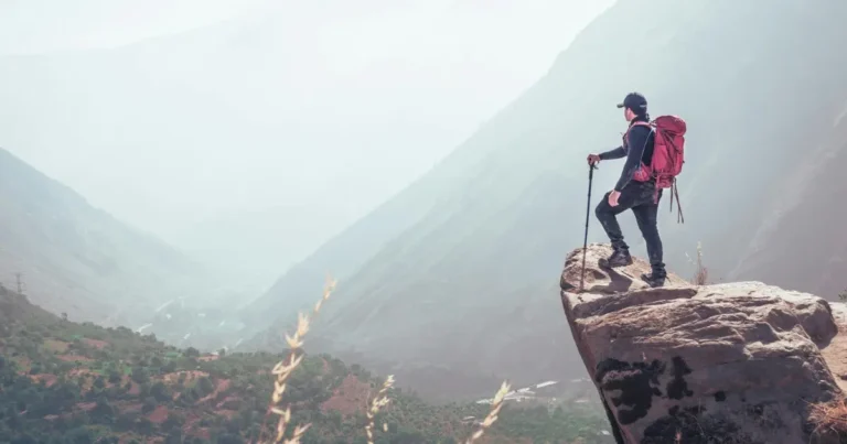 Backpacker hiking with backpack on mountain trail